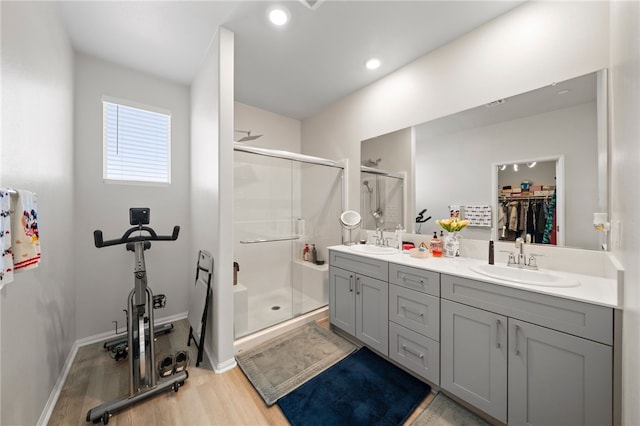 bathroom featuring a shower stall, a sink, and wood finished floors