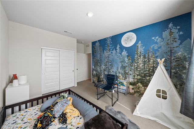carpeted bedroom with visible vents and a closet