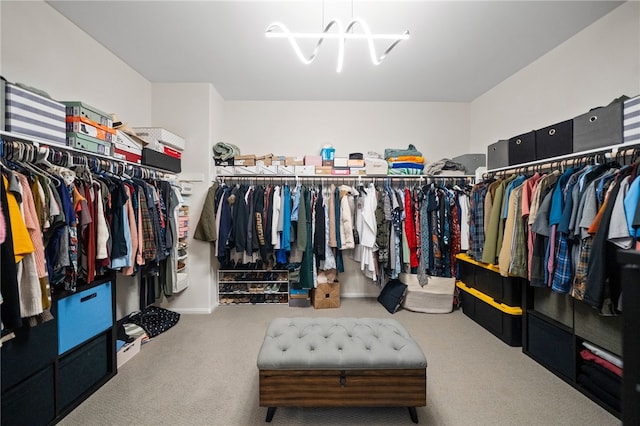walk in closet with carpet floors and a chandelier
