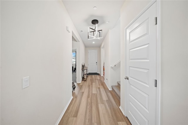 hallway featuring baseboards and light wood finished floors