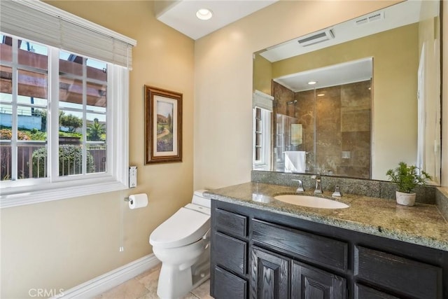 full bathroom featuring tiled shower, toilet, vanity, baseboards, and visible vents