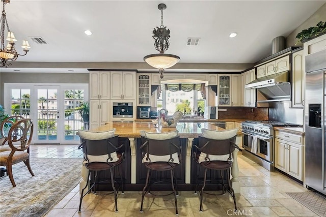 kitchen with a chandelier, visible vents, under cabinet range hood, recessed lighting, and high quality appliances