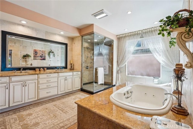 bathroom featuring a sink, double vanity, a stall shower, recessed lighting, and a whirlpool tub