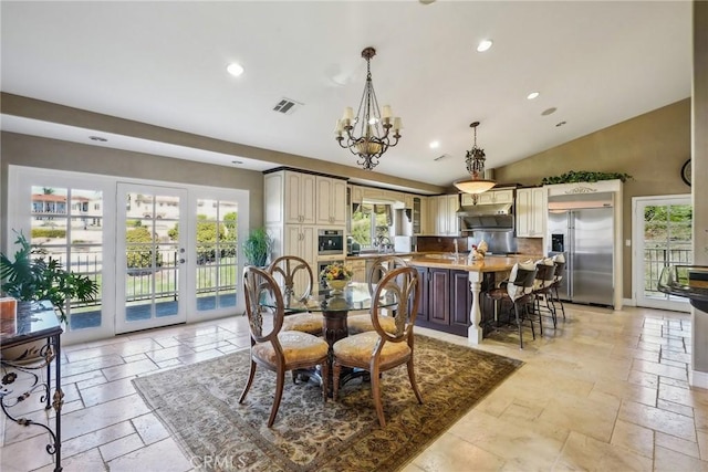 dining room with lofted ceiling, a wealth of natural light, stone tile flooring, and visible vents