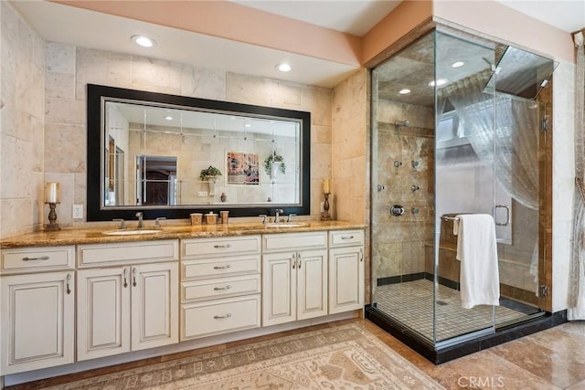 bathroom featuring tile walls, a stall shower, and a sink