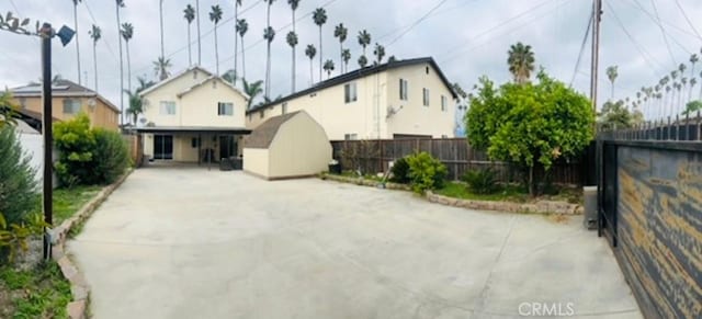 exterior space featuring an outdoor structure, a fenced backyard, a patio area, and a storage shed