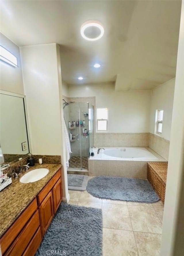 full bathroom with a garden tub, a stall shower, tile patterned floors, and vanity