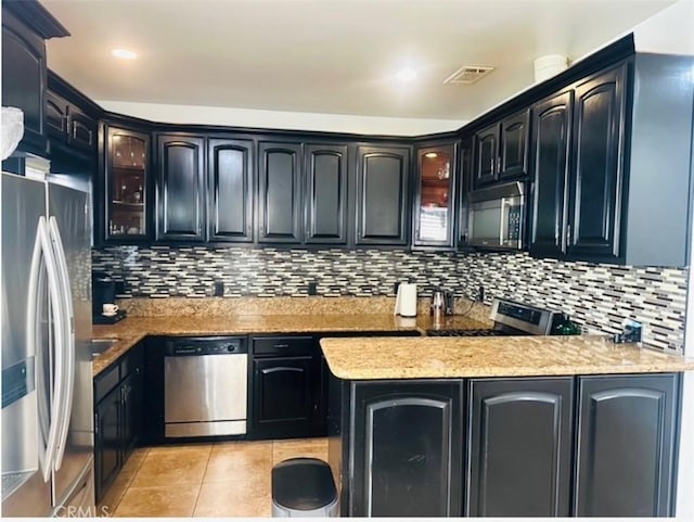kitchen with glass insert cabinets, appliances with stainless steel finishes, light tile patterned flooring, and visible vents