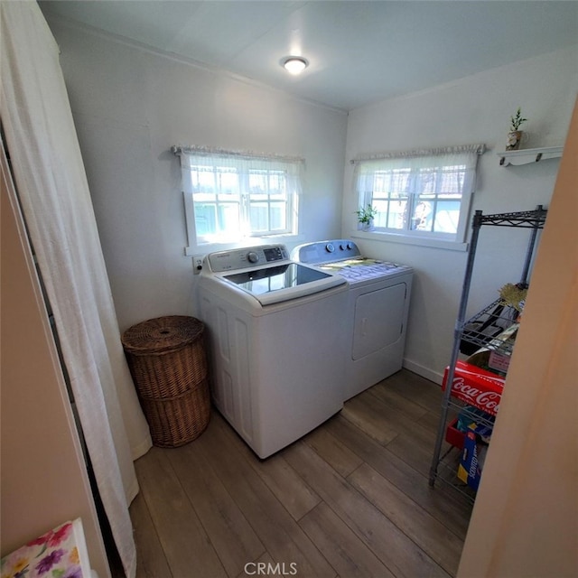 clothes washing area with laundry area, washing machine and clothes dryer, and wood finished floors