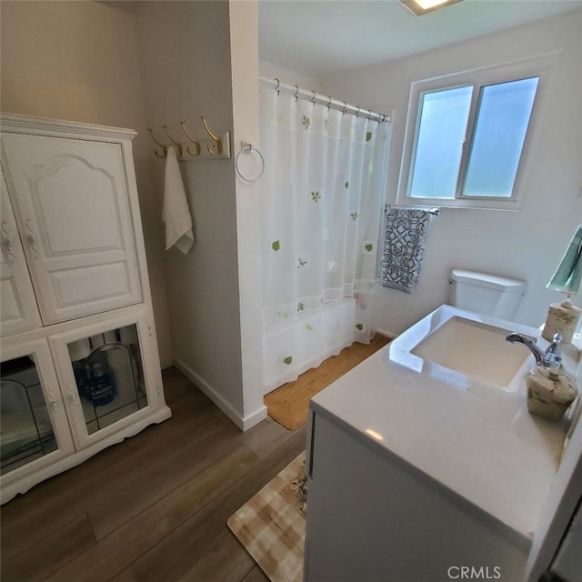 full bathroom with vanity, toilet, wood finished floors, a shower with shower curtain, and baseboards