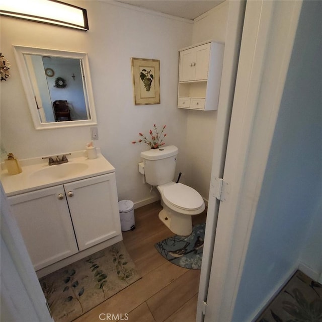 bathroom featuring vanity, toilet, and wood finished floors