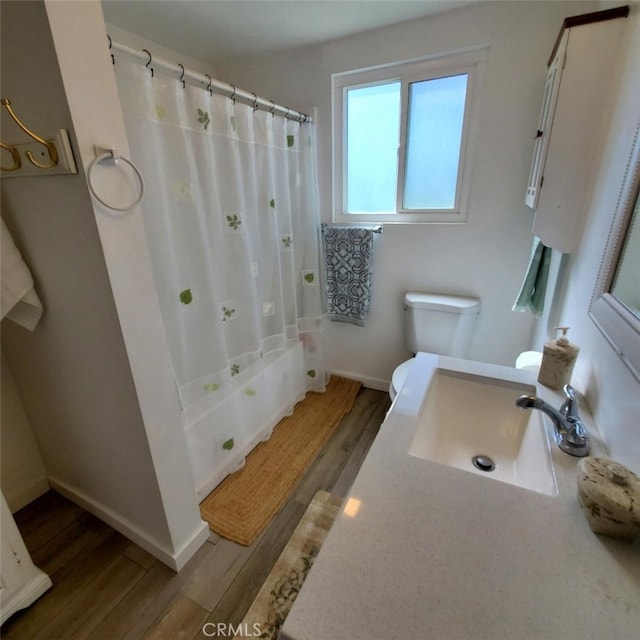 full bathroom featuring toilet, curtained shower, and wood finished floors