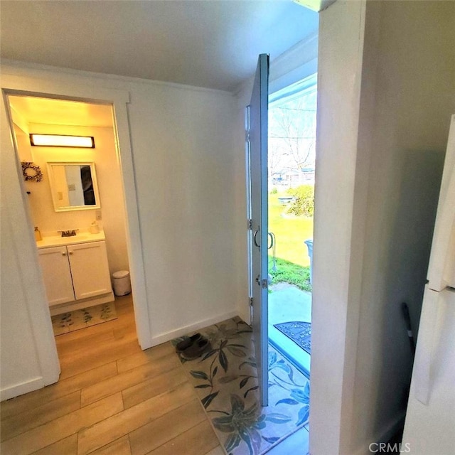entryway with light wood-type flooring and baseboards