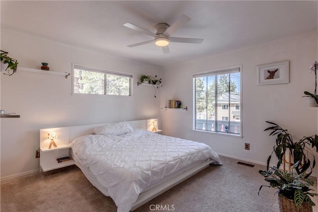 carpeted bedroom featuring ceiling fan, baseboards, and visible vents
