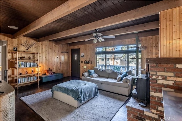 living area with wood finished floors, beam ceiling, and wooden walls