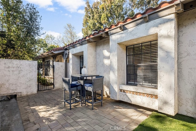 view of patio with a gate and outdoor dining area