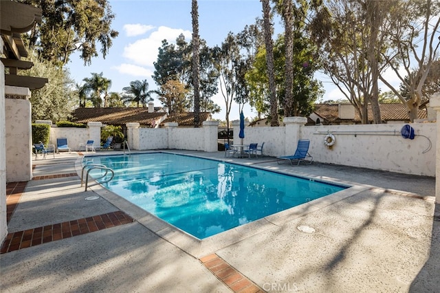 community pool featuring a patio and fence