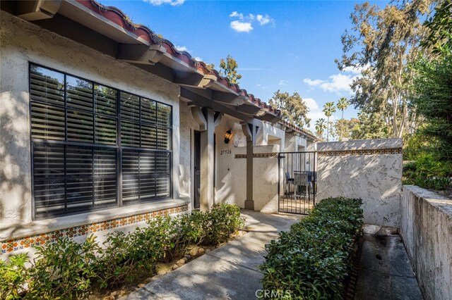 property entrance with a gate and stucco siding