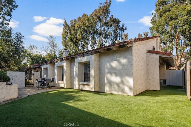 back of property featuring a patio area, a lawn, stucco siding, and fence