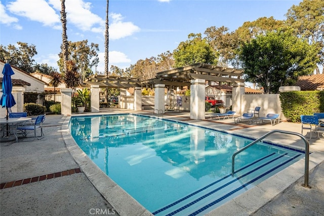 community pool featuring fence, a pergola, and a patio