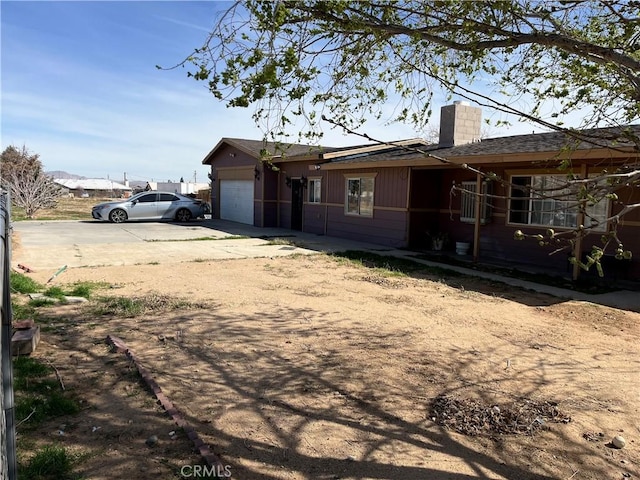 10715 3rd Ave, Hesperia, CA 92345 - view of property exterior featuring concrete driveway, a chimney, and an attached garage