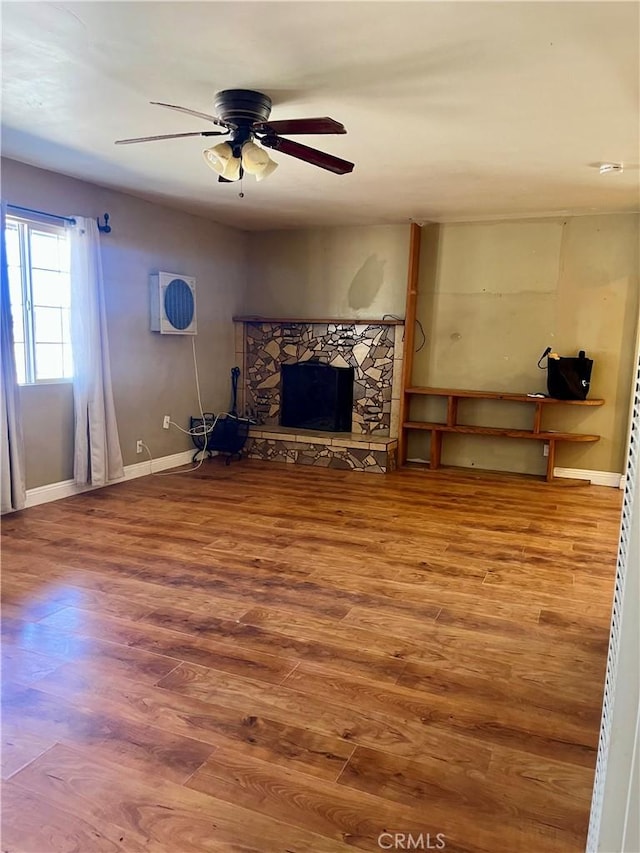 10715 3rd Ave, Hesperia, CA 92345 - unfurnished living room featuring wood finished floors, a ceiling fan, and a fireplace