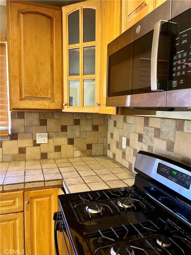 10715 3rd Ave, Hesperia, CA 92345 - kitchen with stainless steel appliances, tasteful backsplash, glass insert cabinets, and tile countertops