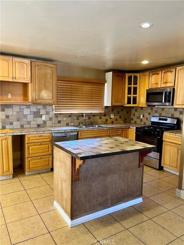 10715 3rd Ave, Hesperia, CA 92345 - kitchen featuring appliances with stainless steel finishes, light tile patterned floors, backsplash, a center island, and glass insert cabinets