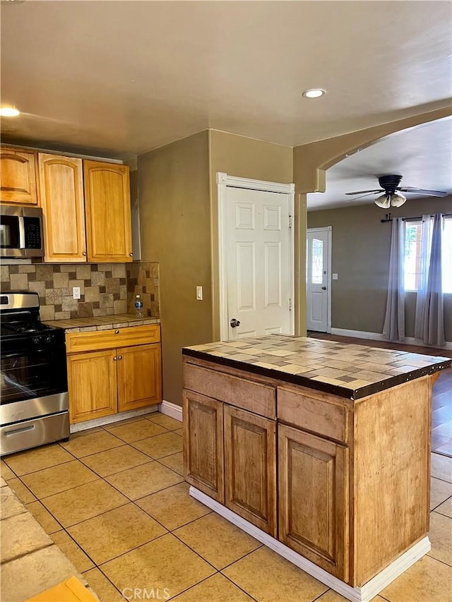 10715 3rd Ave, Hesperia, CA 92345 - kitchen featuring stainless steel appliances, butcher block countertops, a ceiling fan, arched walkways, and tasteful backsplash