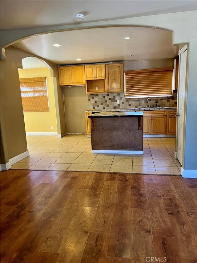 10715 3rd Ave, Hesperia, CA 92345 - kitchen with a center island, tasteful backsplash, arched walkways, light tile patterned flooring, and recessed lighting
