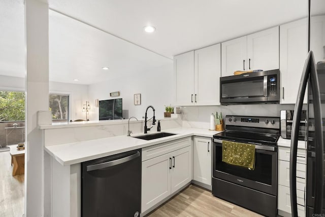 6780 Friars Rd Unit 243, San Diego, CA 92108 - kitchen with appliances with stainless steel finishes, light wood-type flooring, a peninsula, white cabinetry, and recessed lighting