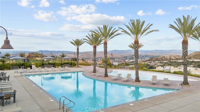 pool featuring a patio and a mountain view