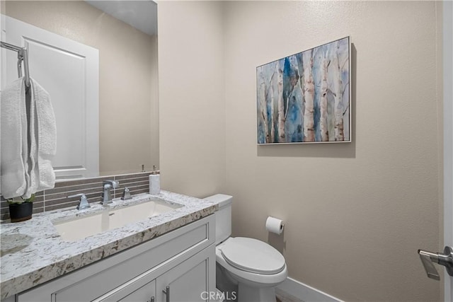 bathroom featuring vanity, baseboards, and toilet