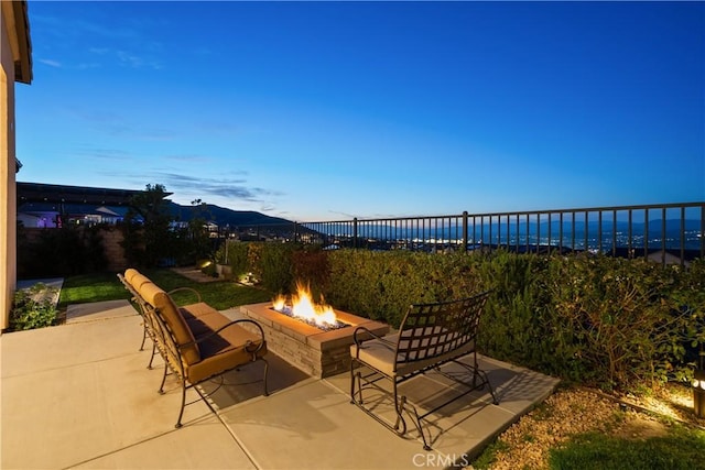 view of patio featuring fence, a fire pit, and a mountain view