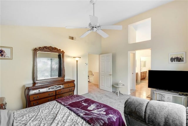 bedroom with high vaulted ceiling, carpet floors, ensuite bath, visible vents, and ceiling fan