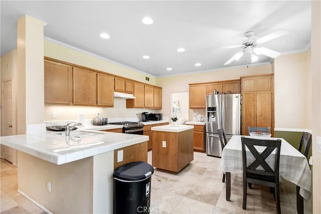 kitchen featuring crown molding, a peninsula, appliances with stainless steel finishes, under cabinet range hood, and a sink