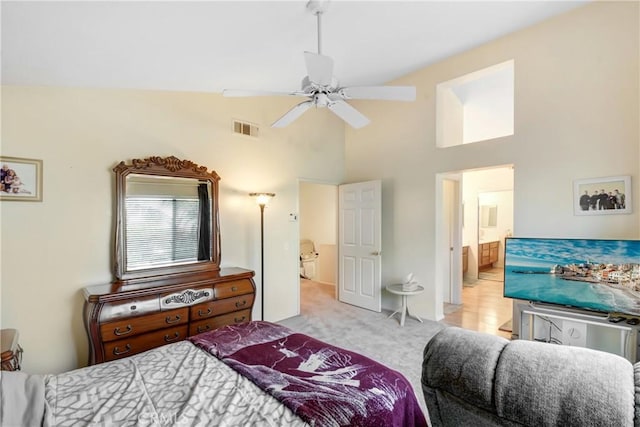 carpeted bedroom featuring high vaulted ceiling, ensuite bathroom, ceiling fan, and visible vents