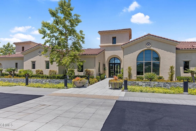 mediterranean / spanish-style home featuring stucco siding and a tile roof