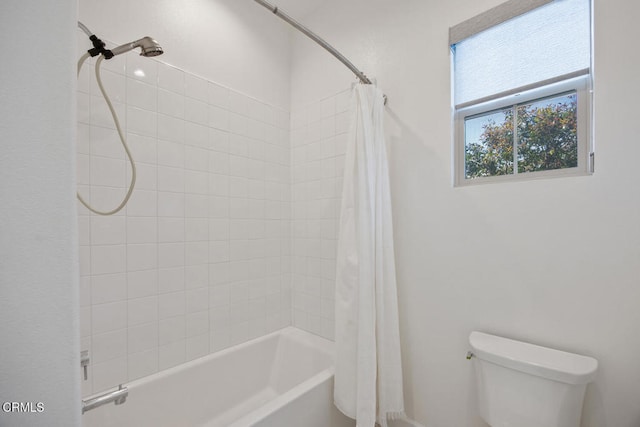 bathroom featuring shower / tub combo with curtain and toilet