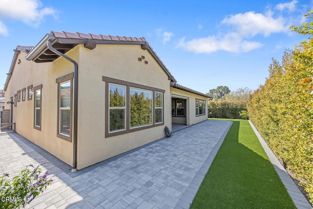 rear view of property with a patio area and stucco siding
