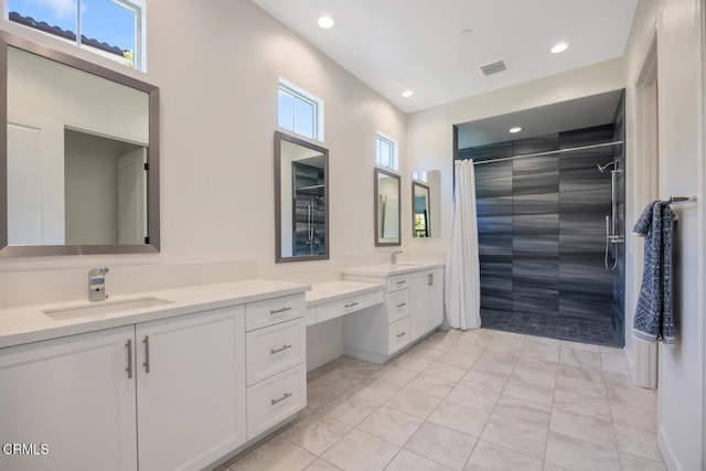 full bathroom featuring recessed lighting, visible vents, tiled shower, and a sink