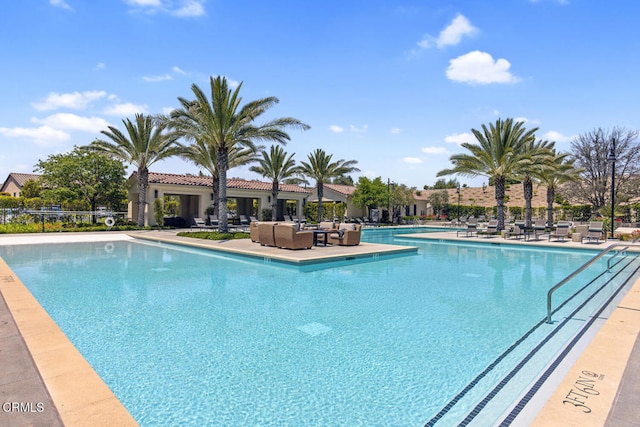 community pool with outdoor lounge area and a patio