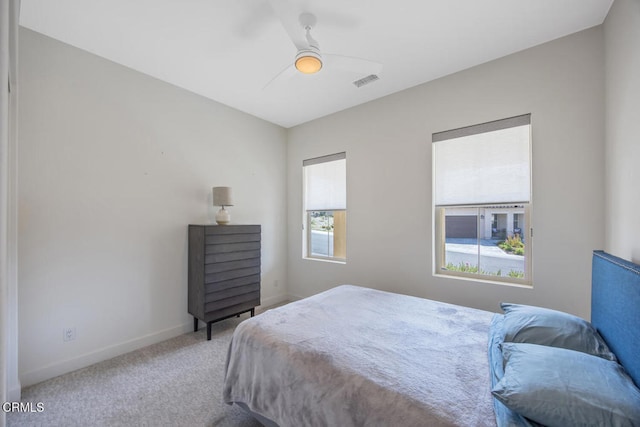 carpeted bedroom with ceiling fan, baseboards, and visible vents