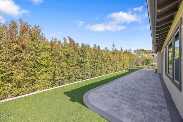 view of yard featuring fence and a patio