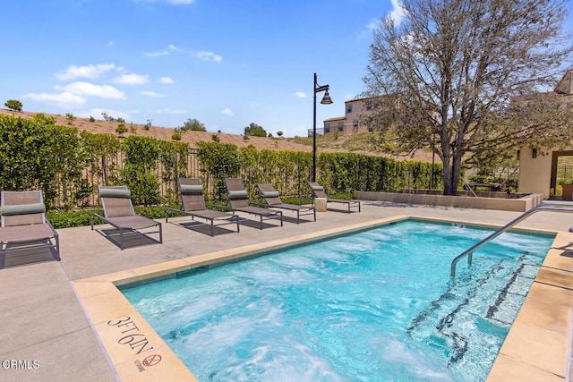 view of pool featuring fence, a patio area, and a swimming pool