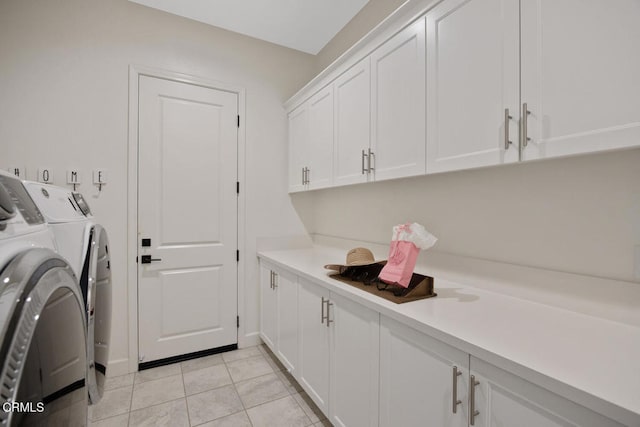 laundry area featuring independent washer and dryer, light tile patterned floors, and cabinet space
