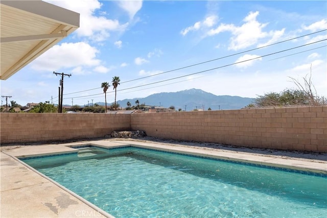 view of swimming pool featuring a fenced backyard, a fenced in pool, and a mountain view
