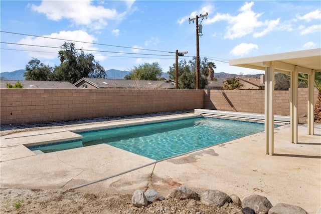 view of pool with a patio, a fenced in pool, a fenced backyard, and a mountain view