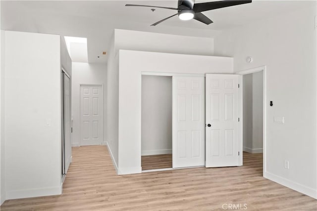 unfurnished bedroom featuring a closet, baseboards, and light wood-style floors