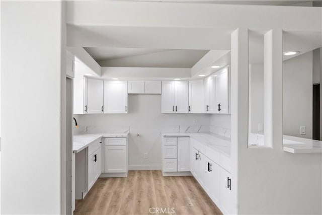 kitchen featuring white cabinets, a sink, and light wood-type flooring